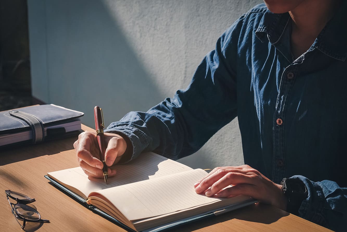 person writing in journal