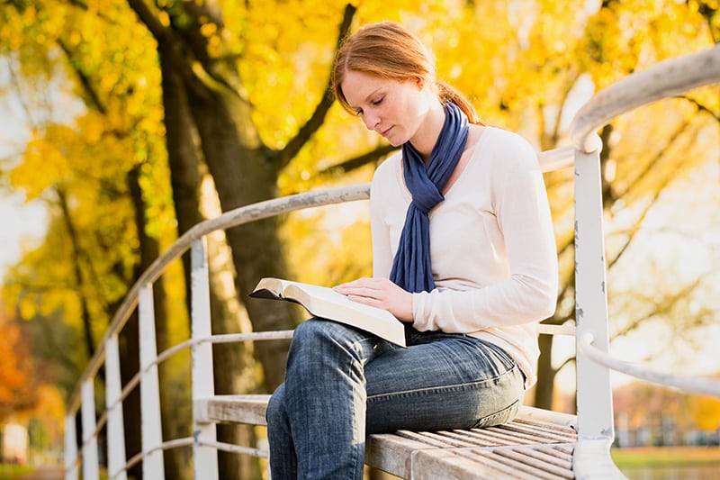 woman reading in autumn park